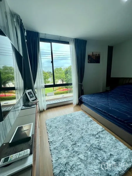 Townhouse for rent - Master bedroom with floor-to-ceiling window and balcony view over greenery.