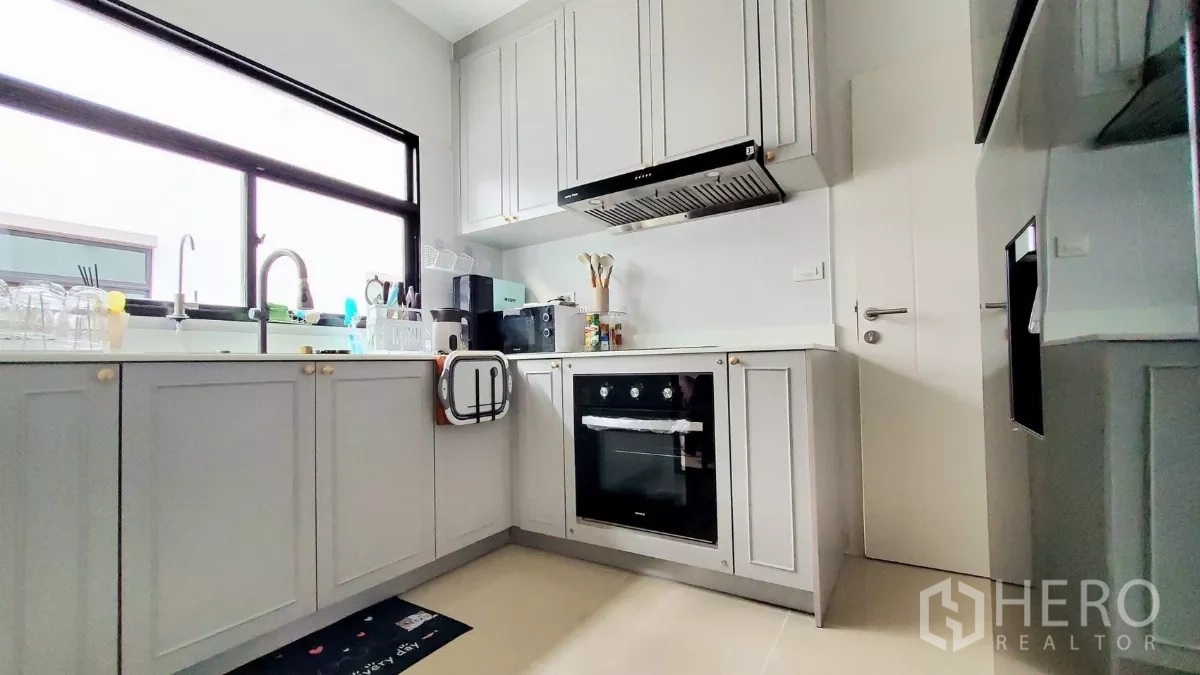 Detached House for rent in Lat Krabang, Bangkok - Fully equipped kitchen featuring oven, range hood and a wide window over the sink.