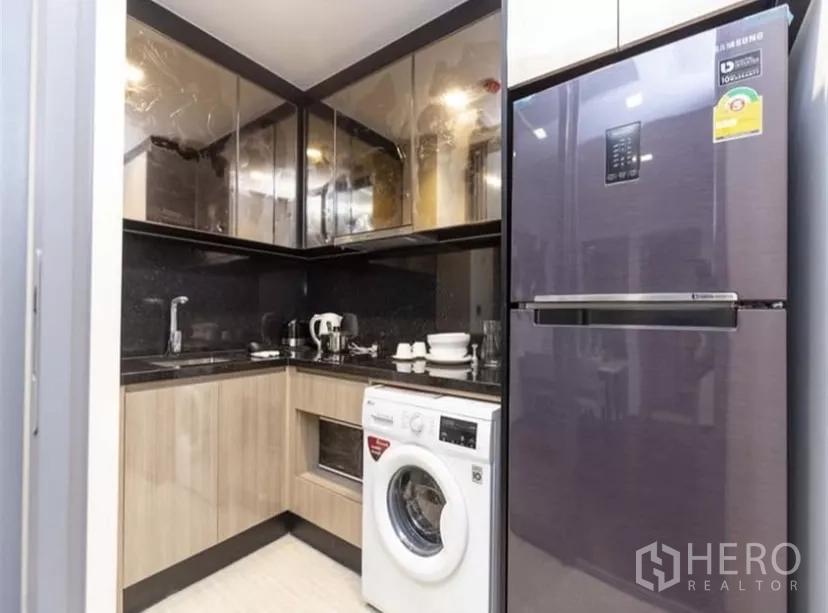 公寓 出租在Ratchathewi, Bangkok - L型厨房，高光柜体，水槽、灶台、洗衣机与大冰箱配置齐全。