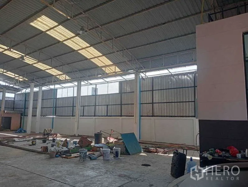 Warehouse for rent in Lam Luk Ka, Pathum Thani - Large warehouse interior with high clearance, skylights and concrete flooring for storage or operations.