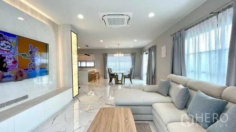 独栋房屋 for rent or sale in Bang Phli, Samut Prakan - 客厅设转角沙发、电视墙与开放式格局