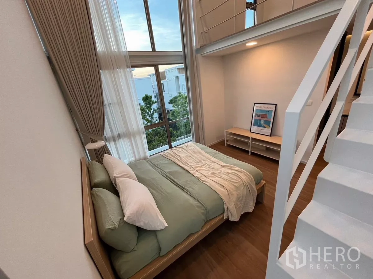 Detached House for rent in Saphan Sung, Bangkok - High-ceiling bedroom with floor-to-ceiling windows and mezzanine-style loft.