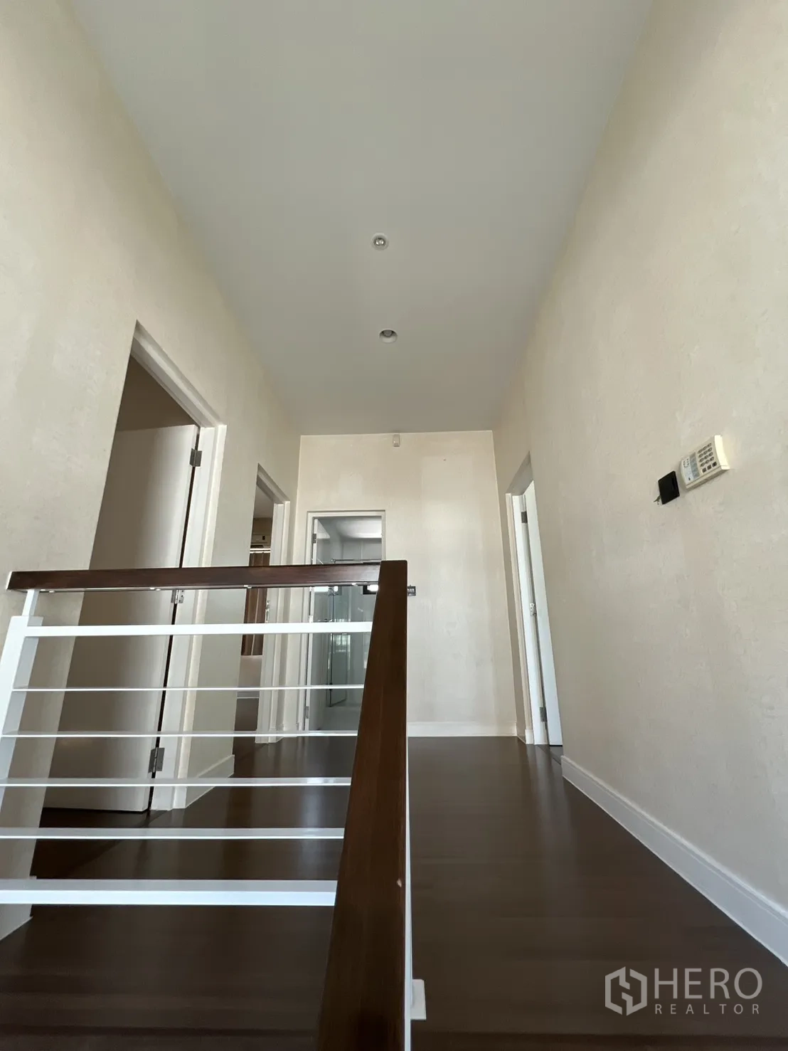 Detached House for sale in Bang Kapi, Bangkok - Upper landing with dark wood flooring and doors to bedrooms.