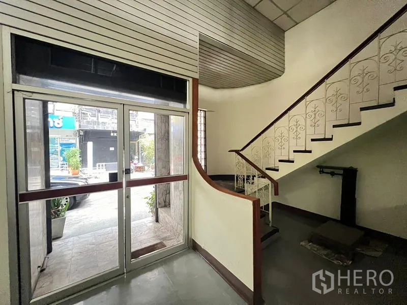 Shophouse for sale - Entrance lobby with sliding glass doors and decorative stair rail.