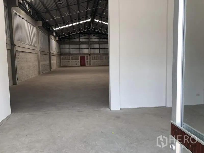 Factory for rent in Khlong Luang, Pathum Thani - View from office doorway into high-clearance warehouse space.