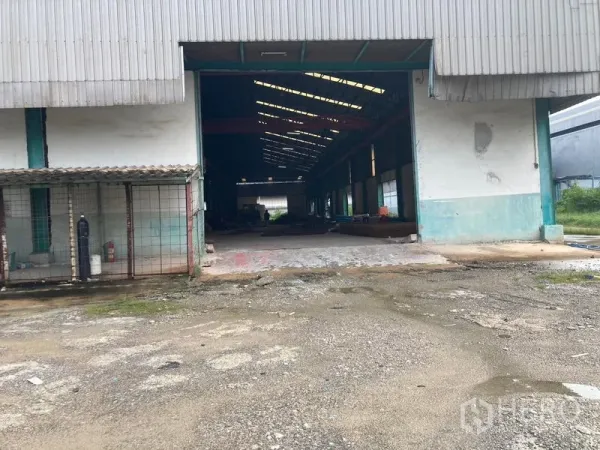 Warehouse for rent in Mueang Samut Sakhon, Samut Sakhon - Large sliding-door bay opening to a high-roof warehouse with skylights and deep interior.