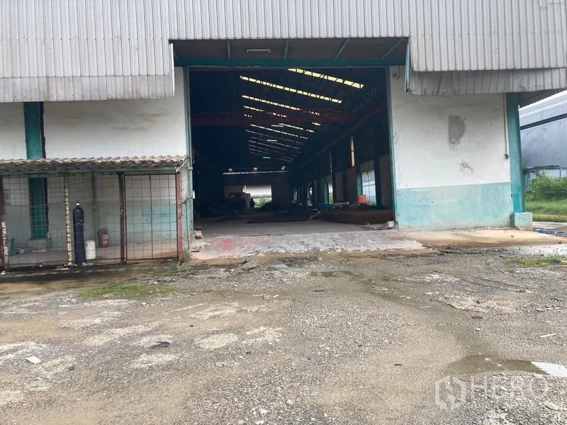 Warehouse for rent in Mueang Samut Sakhon, Samut Sakhon - Large sliding-door bay opening to a high-roof warehouse with skylights and deep interior.