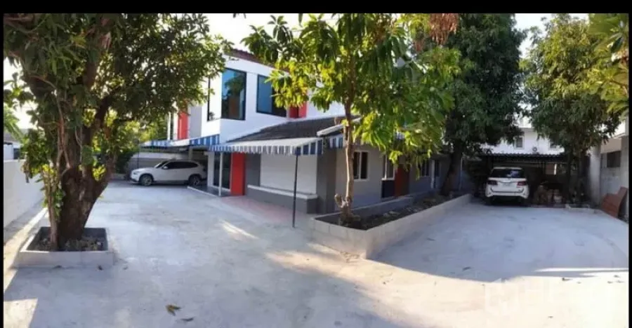 独立式住宅 出租在Lat Phrao, Bangkok - 曼谷拉抛两层独栋别墅外观，宽阔水泥车道、成荫大树与双车位车棚。