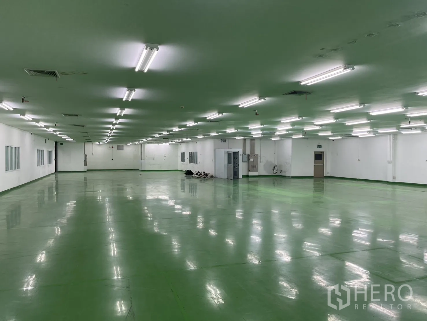 工厂 for rent in Mueang Samut Prakan, Samut Prakan - 室内工厂空间，白色墙面、办公室窗、配电柜与多处出入口。