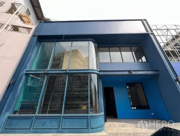 Retail Space for rent in Phaya Thai, Bangkok - Two-storey retail building in Phaya Thai, Bangkok, with a blue facade and curved floor-to-ceiling glass corner.