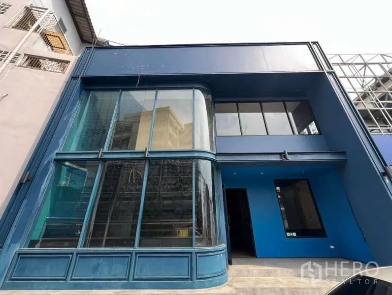 Retail Space for rent in Phaya Thai, Bangkok - Two-storey retail building in Phaya Thai, Bangkok, with a blue facade and curved floor-to-ceiling glass corner.