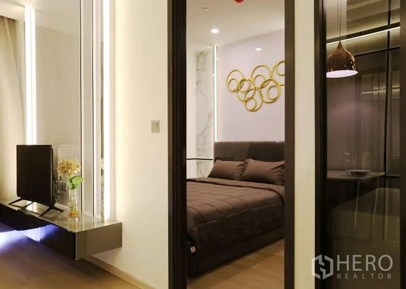 公寓 出租在Watthana, Bangkok - 从客厅望向卧室的滑门视角，电视柜与玻璃隔断