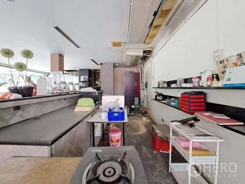 Retail Space for rent - Retail unit interior with long service counter, open shelving and bright window light.