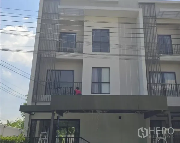 Townhouse for rent or sale in Saphan Sung, Bangkok - Modern three-storey townhouse facade with balconies and covered carport.