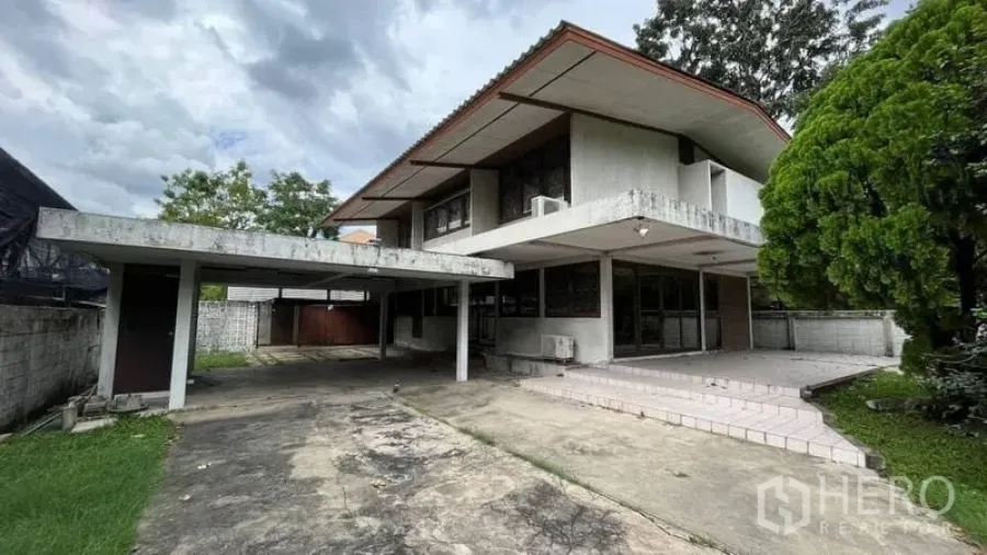 บ้าน ให้เช่า - ภาพภายนอกบ้านเดี่ยวสองชั้น พร้อมที่จอดรถกว้างและชานหน้าบ้านปูกระเบื้อง