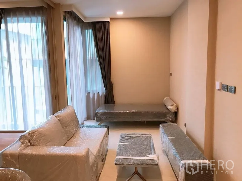 คอนโด ให้เช่าในWatthana, Bangkok - ห้องนั่งเล่นสว่างด้วยหน้าต่างเต็มบาน โซฟา เดย์เบด และผ้าม่านทึบ