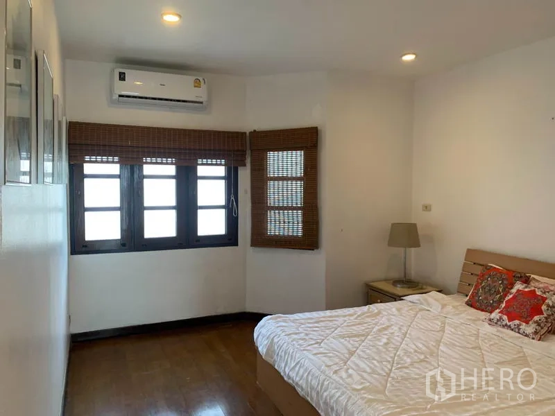 联排别墅 出租或出售在Phra Khanong, Bangkok - 温馨卧室，双人床、竹木百叶窗与嵌灯及空调。