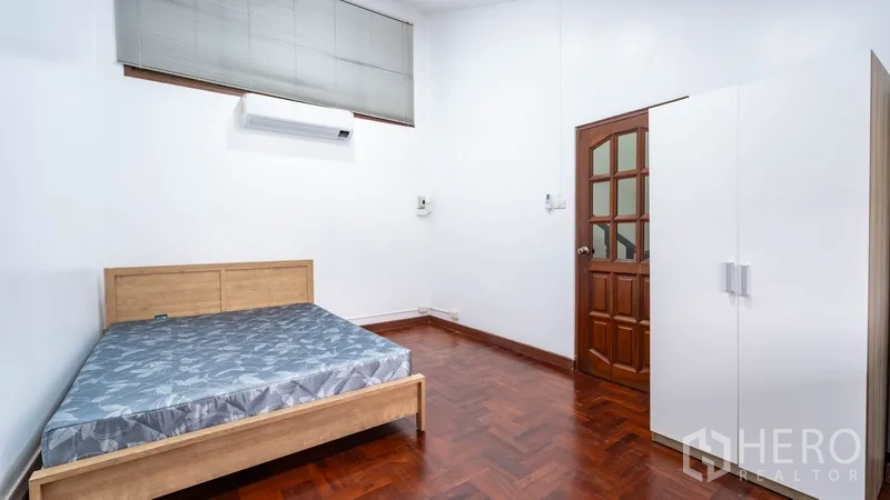 Townhouse for rent in Watthana, Bangkok - Bedroom with double bed, air conditioner, and wardrobe.