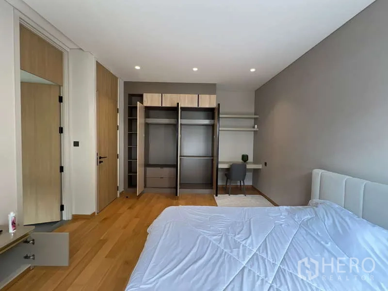 Detached House for rent in Suan Luang, Bangkok - Bedroom with open wardrobes, study desk and wood floors.