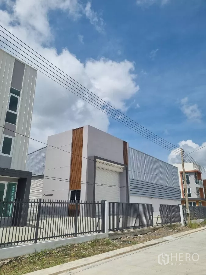 货栈 出售在Lam Luk Ka, Pathum Thani - 近景：仓库卷闸装卸口与围栏。