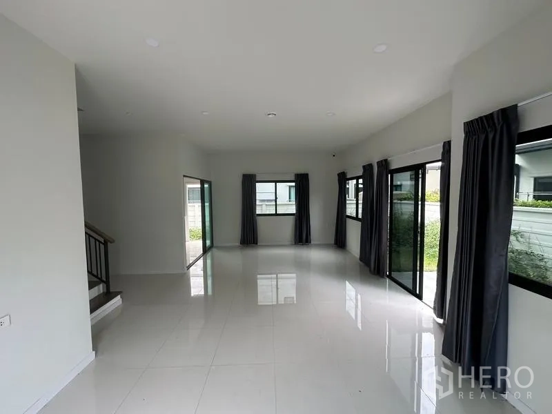 独立式住宅 出售在Khlong Sam Wa, Bangkok - 采光充足的客厅，亮白地砖与落地窗