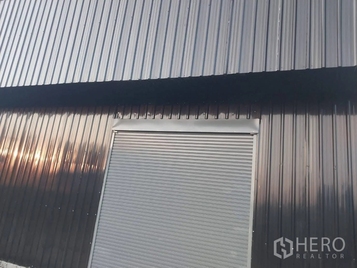 Warehouse for rent in Lat Krabang, Bangkok - Close-up of the metal-clad facade featuring a roller shutter door.