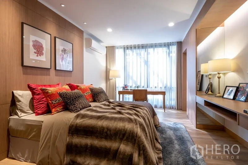 Condominium for sale - Cozy bedroom with king bed, accent pillows and a work desk beside a large window.