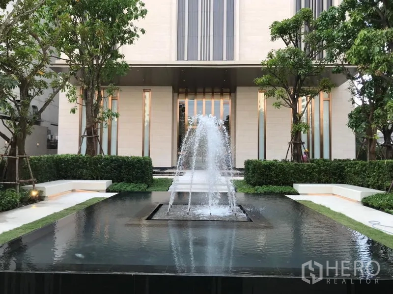 คอนโด ให้เช่าหรือขายในWatthana, Bangkok - ทางเข้าอาคารคอนโดพร้อมน้ำพุโดดเด่น พุ่มไม้ตัดแต่ง และอาคารด้านหน้า