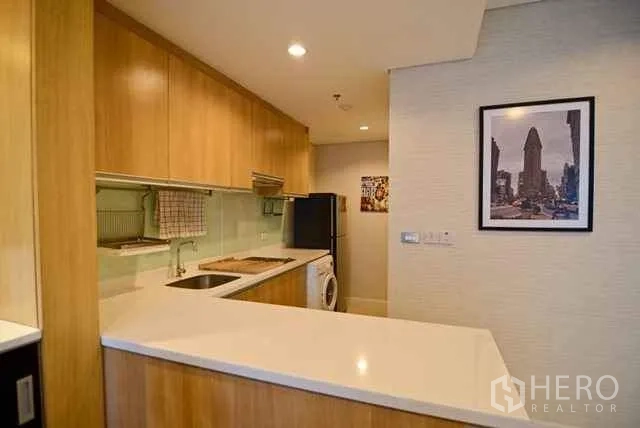 公寓 出租或出售在Ratchathewi, Bangkok - 开放式L形木质厨房，白色台面、水槽与洗衣机。