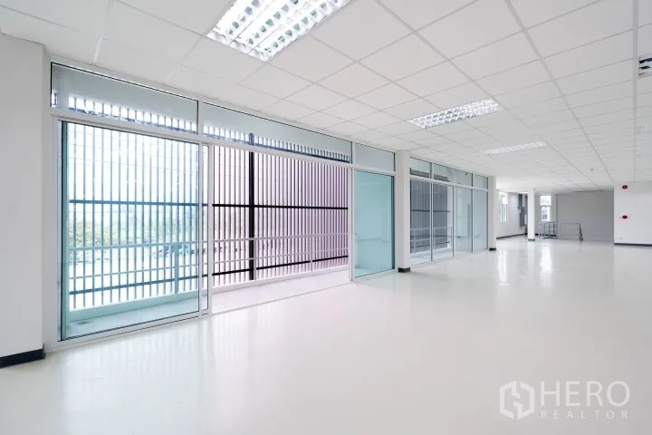 Factory for rent in Khlong Luang, Pathum Thani - Large office room with sliding glass doors and floor-to-ceiling windows.