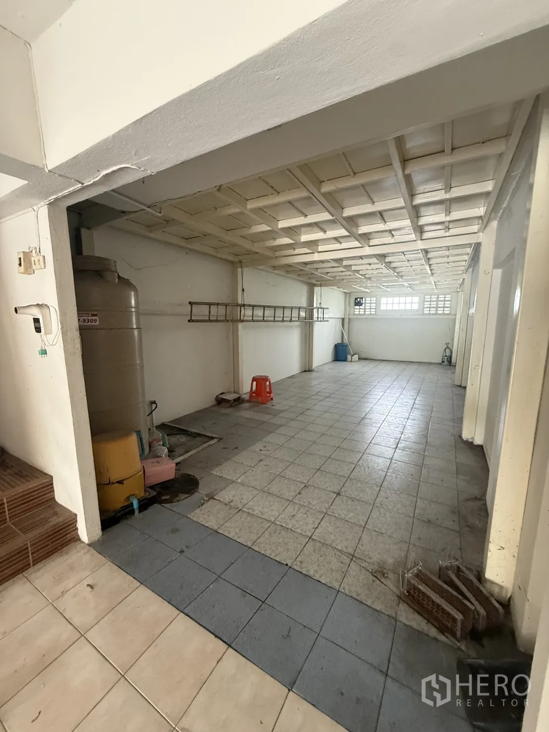 Shophouse for rent in Pak Kret, Nonthaburi - Rear ground-floor zone with water tank and equipment by tiles.
