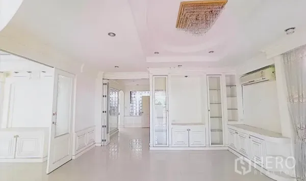 独立式住宅 出售在Bang Kapi, Bangkok - 白色客厅，亮面地砖、筒灯与内置展示柜。
