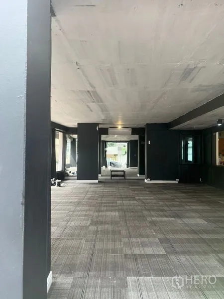 Retail Space for rent in Watthana, Bangkok - Long view of empty retail floor with mirrors, overhead lighting and an air‑conditioning unit.