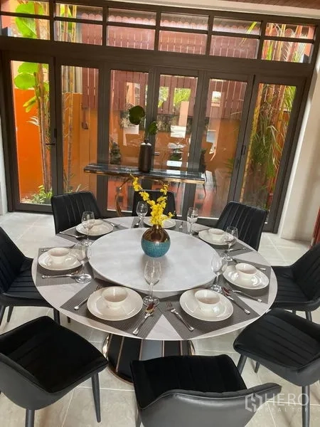 Detached House for rent in Suan Luang, Bangkok - Pool‑view dining space with sliding glass doors and greenery outside.