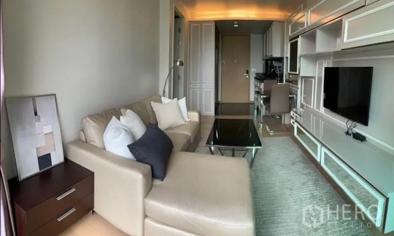 คอนโด ให้เช่าในWatthana, Bangkok - มุมมองพาโนรามาของห้องนั่งเล่น โซฟาเข้ามุม ชั้นวางทีวีบิวท์อิน พรม และครัวย่อม