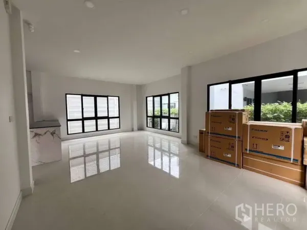 Detached House for rent in Wang Thonglang, Bangkok - Bright open living room with large black-framed windows and glossy tiled floors.