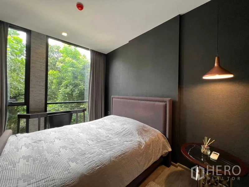 公寓 出租在Watthana, Bangkok - 主卧带大窗与床头柜，欣赏花园绿景。