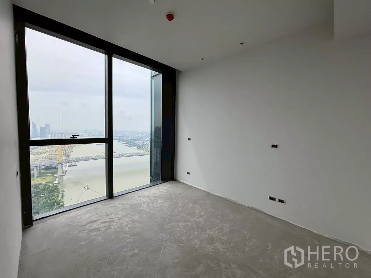 Condominium for sale in Bang Kho Laem, Bangkok - Bedroom shell with a full-height window overlooking the river and bridge.