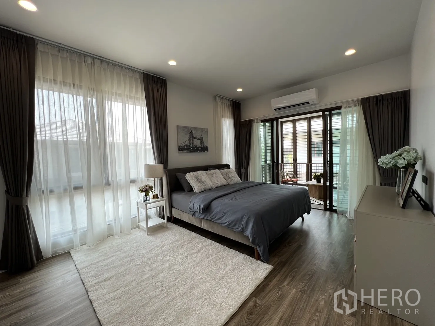 Detached House for rent in Bang Kapi, Bangkok - Master bedroom with large windows, enclosed balcony and air conditioning.