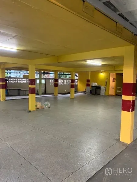 零售空间 出租在Ratchathewi, Bangkok - 开阔大厅，黄色立柱与磨石地面，适合作为座位区或展厅