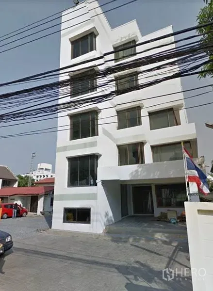 Office Space for rent in Bang Kapi, Bangkok - White mid-rise office building exterior with large windows and a paved forecourt in Bang Kapi.