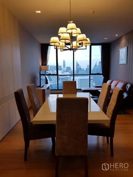 Condominium for rent in Watthana, Bangkok - Dining area with chandelier, six chairs and floor-to-ceiling city view