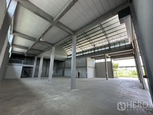 Factory for rent in Lam Luk Ka, Pathum Thani - Open-plan warehouse space with multiple pillars and natural light from high windows.