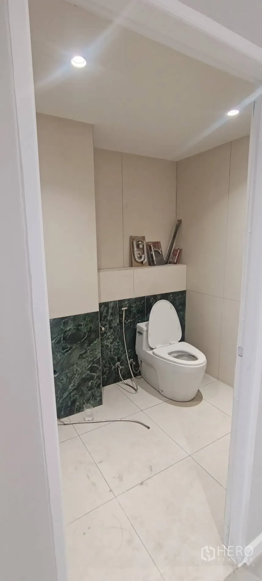 Office Space for rent in Watthana, Bangkok - Modern bathroom with toilet, beige walls, and green marble-style tiles.