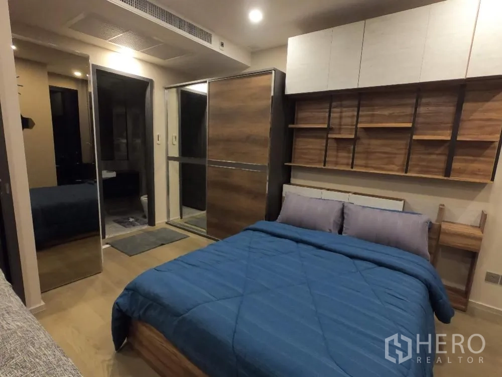 คอนโด for rent in Watthana, Bangkok - มุมห้องนอนพร้อมชั้นบิวท์อิน ตู้เก็บของเหนือศีรษะ และตู้เสื้อผ้าบานเลื่อนลายไม้กระจก