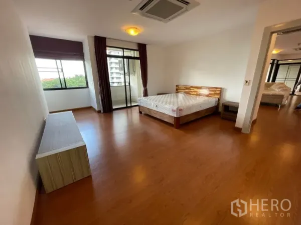 คอนโด ให้เช่าในWatthana, Bangkok - ห้องนอนหลัก พื้นไม้ เชื่อมต่อระเบียง พร้อมหน้าต่างบานใหญ่และโทนสีเรียบ