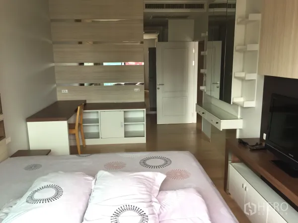 公寓 出租在Bangkok - 卧室采光好，带内置书桌、镜面层架与木地板。