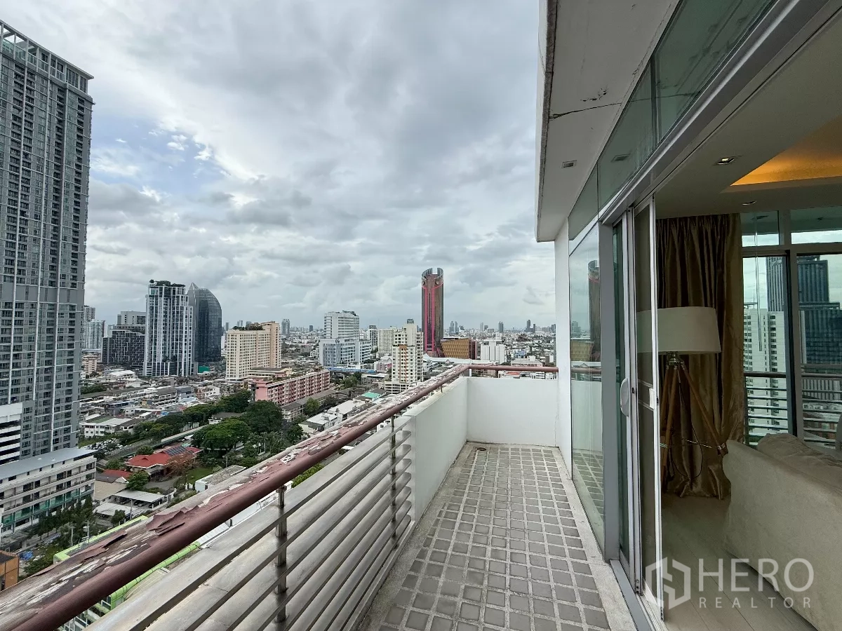 Condominium for rent in Phaya Thai, Bangkok - High‑floor balcony with metal railing and sliding doors overlooking Bangkok high‑rises.