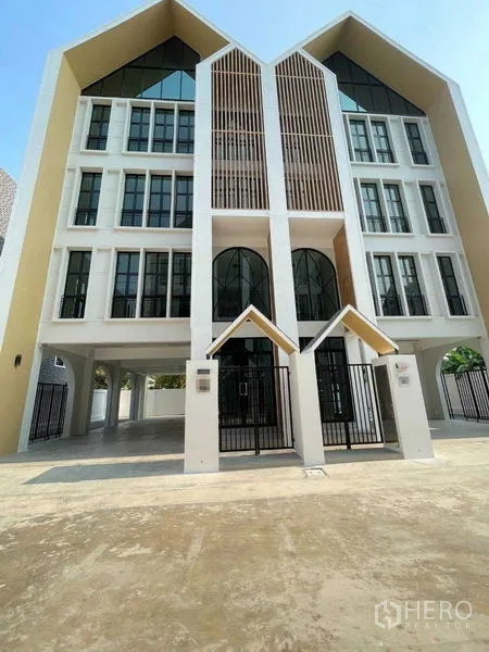 带办公室的家 出租在Bang Kapi, Bangkok - 当代山墙式立面，双入口与拱形窗的Home Office。
