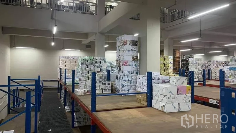 Warehouse for sale in Bangkok Yai, Bangkok - Mezzanine storage zone with pallets and suspended lights.